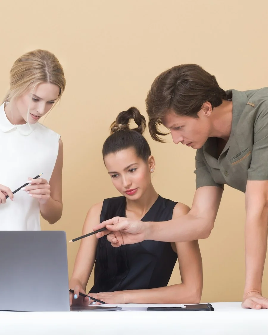 Consultants reviewing CRM strategy with a client on a laptop